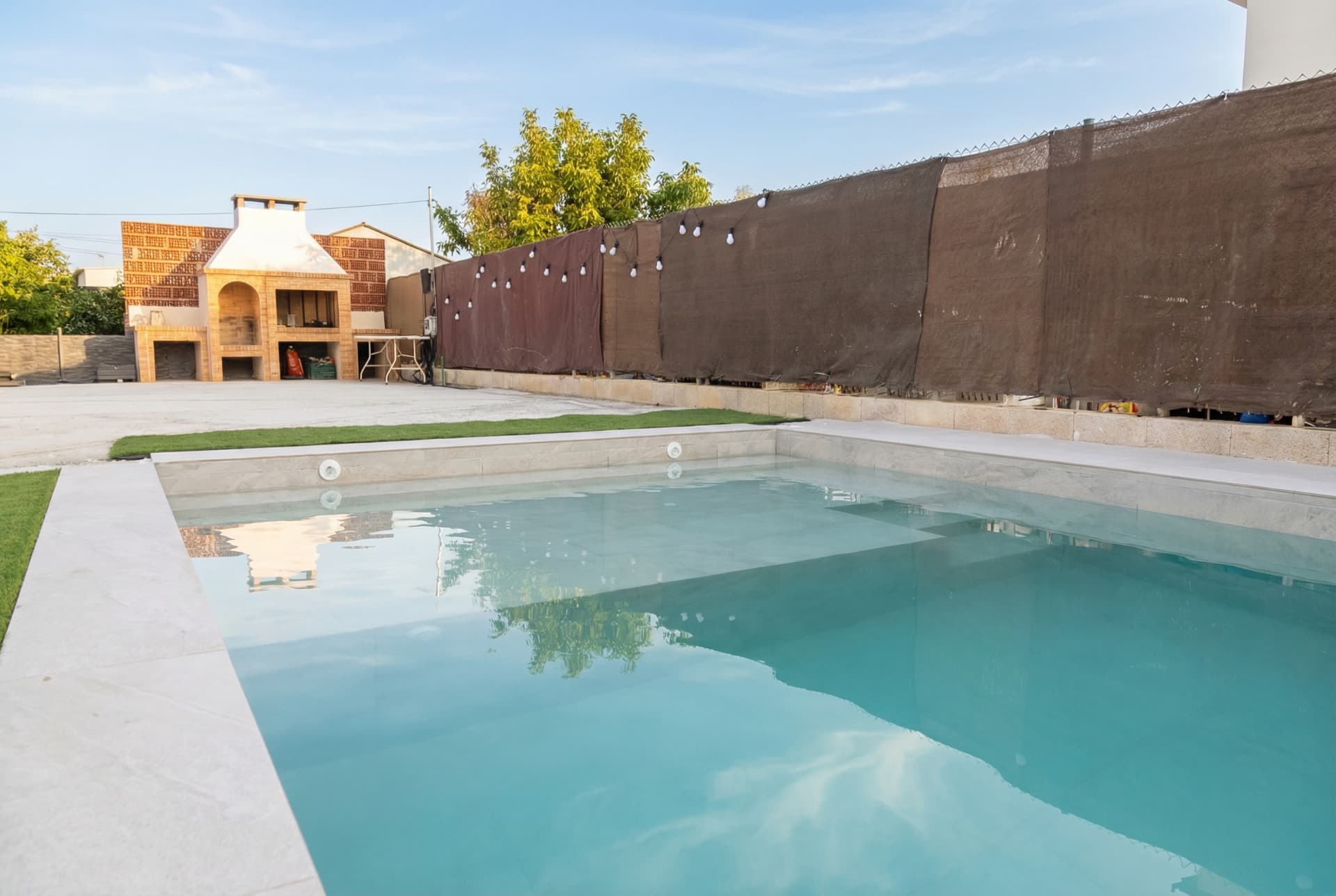 Piscina de hormigón proyectado con playa sumergida y zona spa.