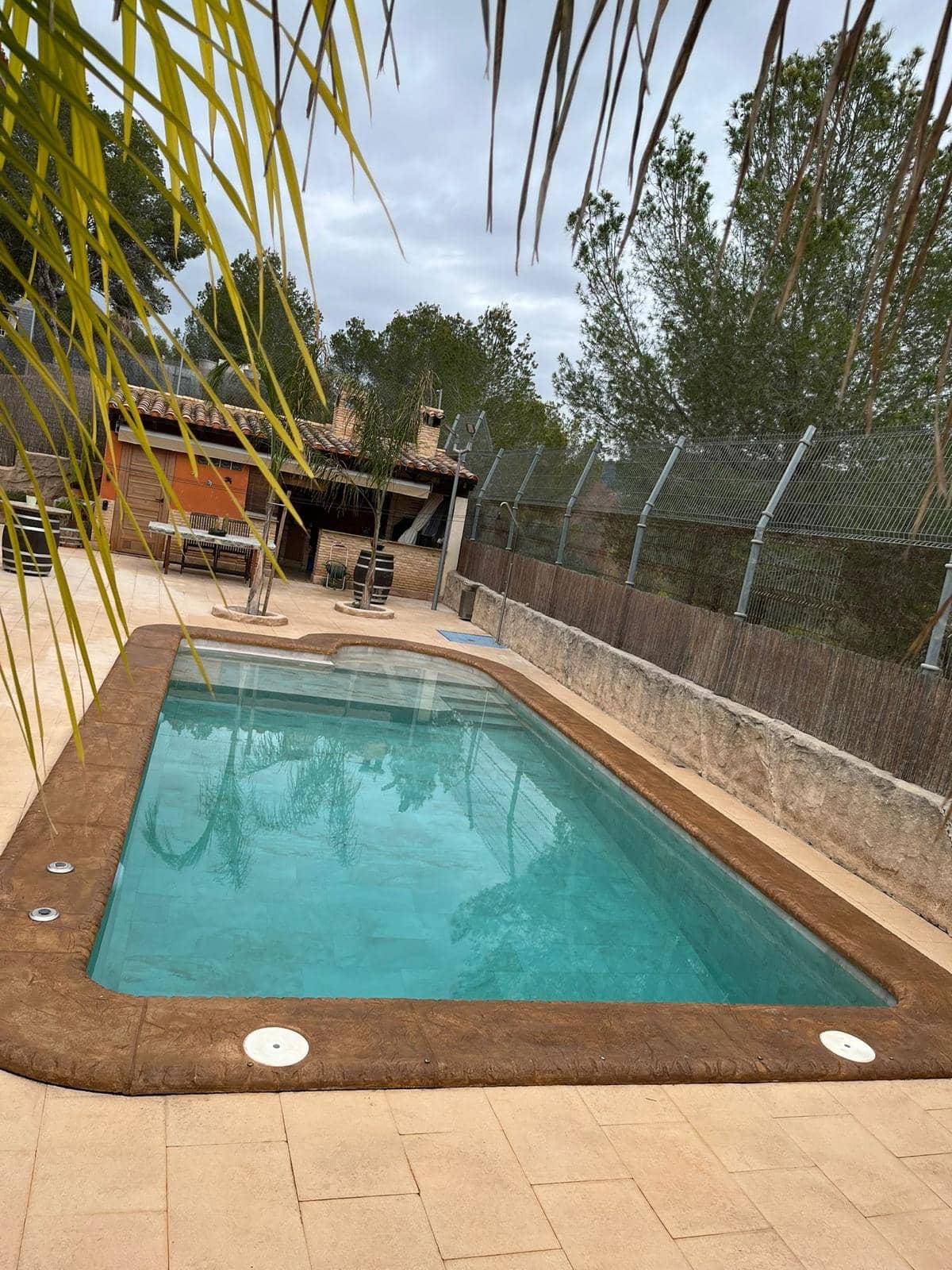 Piscina a medida de hormigón proyectado con escalera lateral.